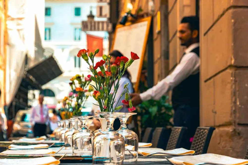 Barista – italienische Gastronomie mit gedeckten Tischen und Servicepersonal