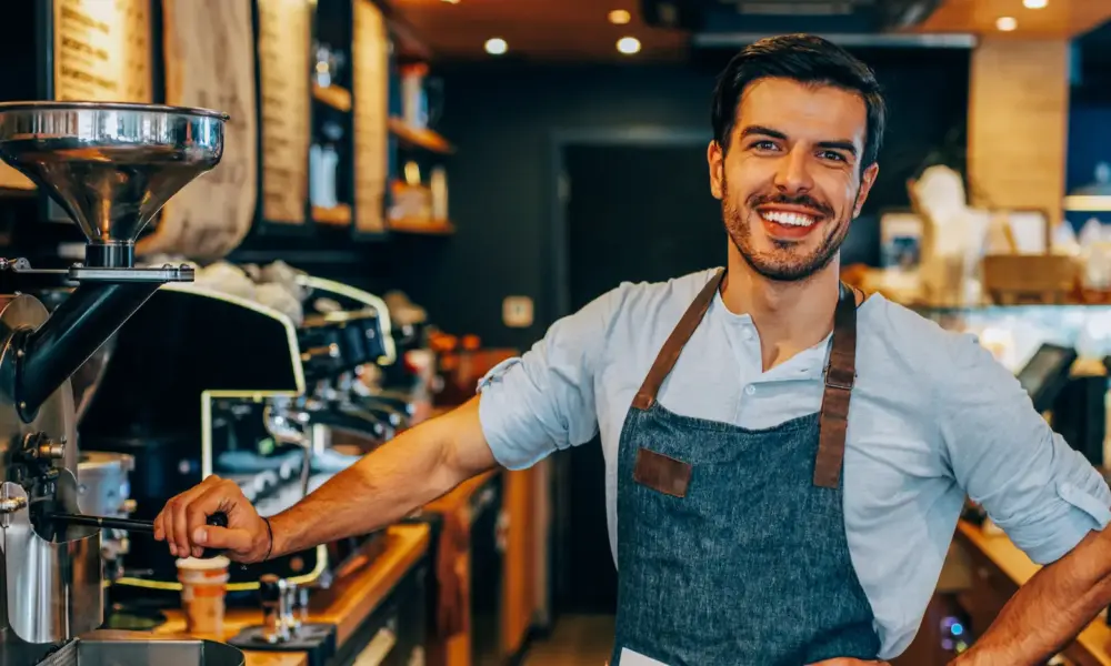 Barista – Mitarbeiter an einer professionellen Espressomaschine in einer Kaffeebar