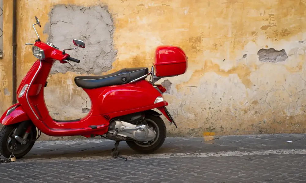 Toskana Wochenschau – rote Vespa vor einer verwitterten Hauswand in Italien