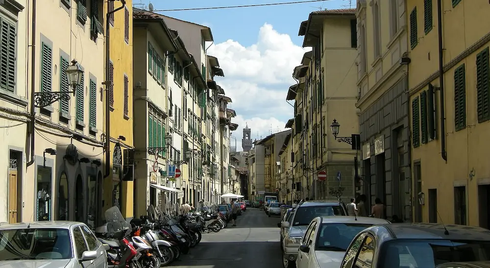 Toskana Wochenschau – Via Palazzuolo in Florenz mit Wohnhäusern, Autos und Motorrollern