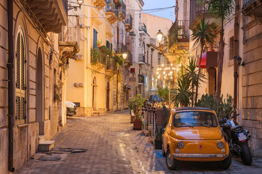Leben in Italien – historische Gasse mit Fiat 500 in einer italienischen Altstadt