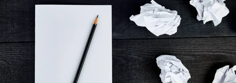 Buchprojekt pausieren – leeres Blatt mit Bleistift und zerknülltem Papier
