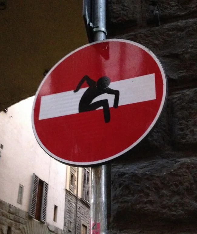 Toskana Wochenschau – Clet-Abraham-Verkehrsschild mit kletternder Figur in Florenz