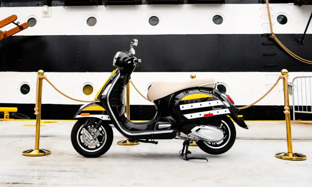 Schwarz-weiße Vespa im Design der Amerigo Vespucci vor dem Rumpf des italienischen Segelschulschiffs
