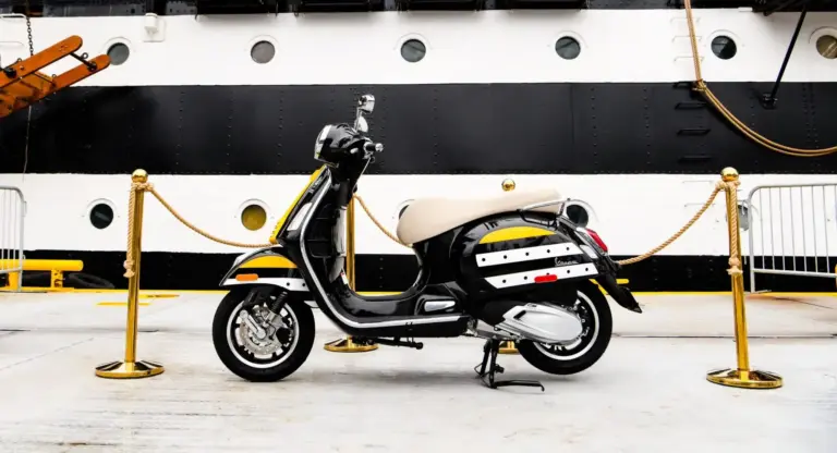 Schwarz-weiße Vespa im Design der Amerigo Vespucci vor dem Rumpf des italienischen Segelschulschiffs