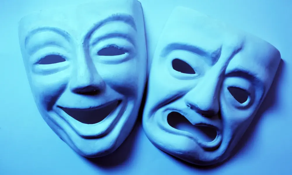 Schöne Worte sind nicht immer wahr – lachende und traurige Theatermaske als Symbol für Schein und Wahrheit