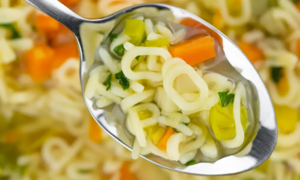 Schreiben Gedanken – Buchstabensuppe mit Nudeln und Gemüse als Bild für ungeordnete Gedanken beim Schreiben