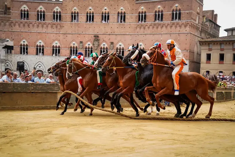 Toskana Wochenschau: Fantini und Pferde beim Start des Palio di Siena auf der Piazza del Campo