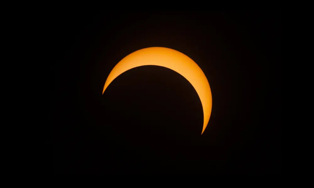 Partielle Sonnenfinsternis mit orangefarbener Sonnensichel vor schwarzem Himmel – Toskana Wochenschau