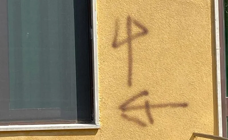 Toskana Wochenschau: Braune Markierungen und ein Pfeil auf einer gelben Hausfassade in Pisa