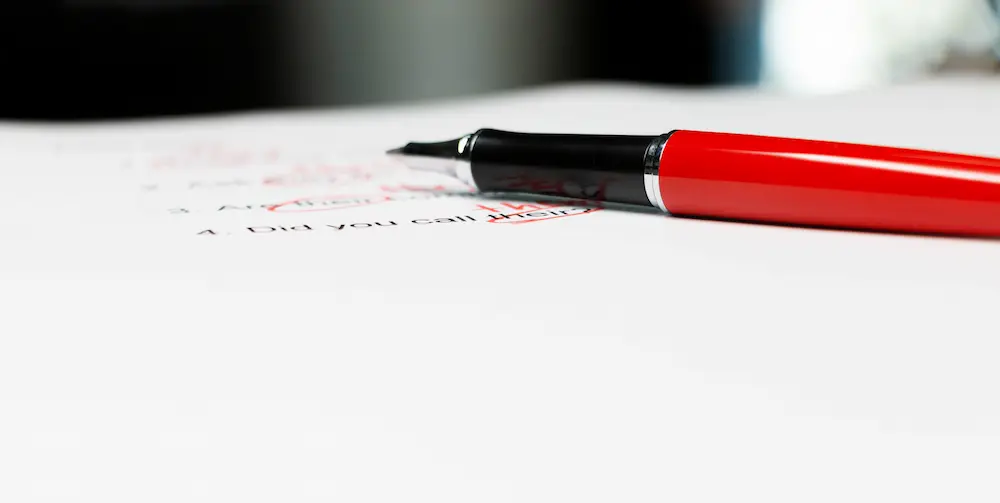 Korrektorat Korrektur – roter Stift auf einem korrigierten Text mit Markierungen