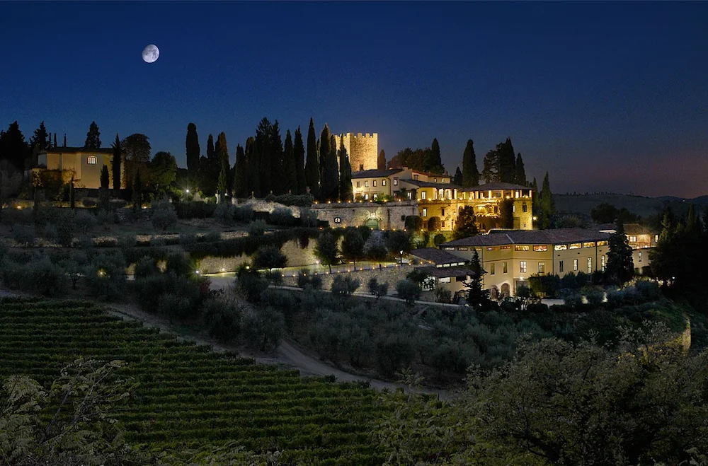Toskana Wochenschau – Castello di Verrazzano bei Nacht mit beleuchtetem Anwesen und Mond über den Weinbergen