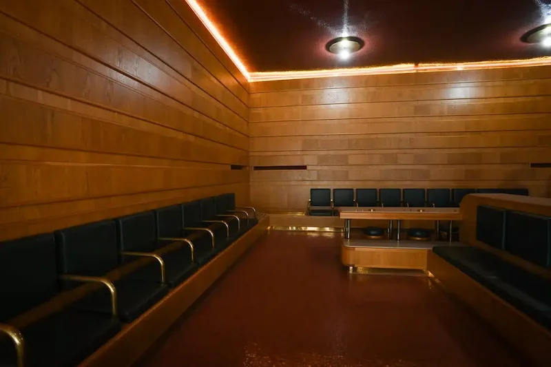 Toskana Wochenschau – Wartesaal zweiter Klasse in den Mazzoni-Sälen von Montecatini Terme mit grünen Sitzpolstern und Holzverkleidung
