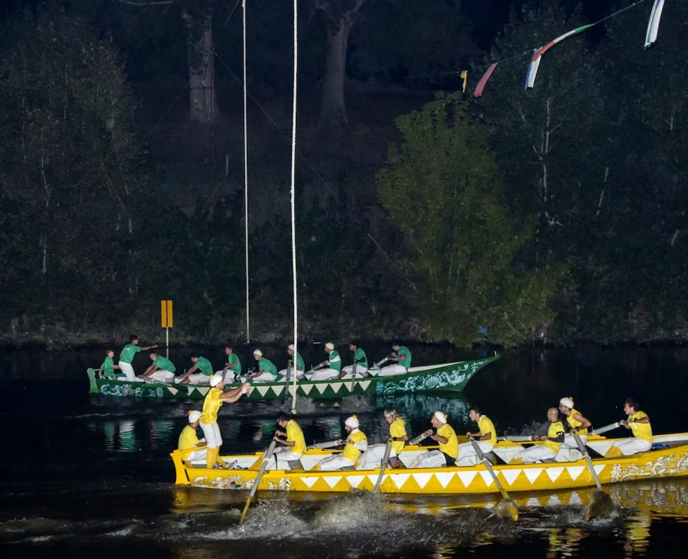 Toskana Wochenschau – zwei Ruderboote bei einem nächtlichen Palio auf dem Wasser