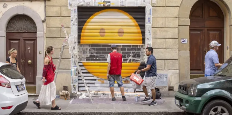 Toskana Wochenschau – großes Smiley-Gesicht als Streetart auf einem Rollladen