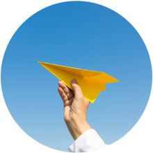 Papierflugzeug, das in den Himmel fliegt, symbolisiert Kreativität und Freiheit.